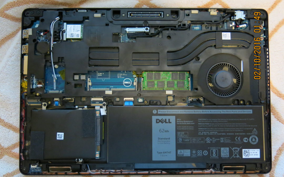 A view of the bottom of a Dell laptop computer with the cover removed, exposing the internal components.