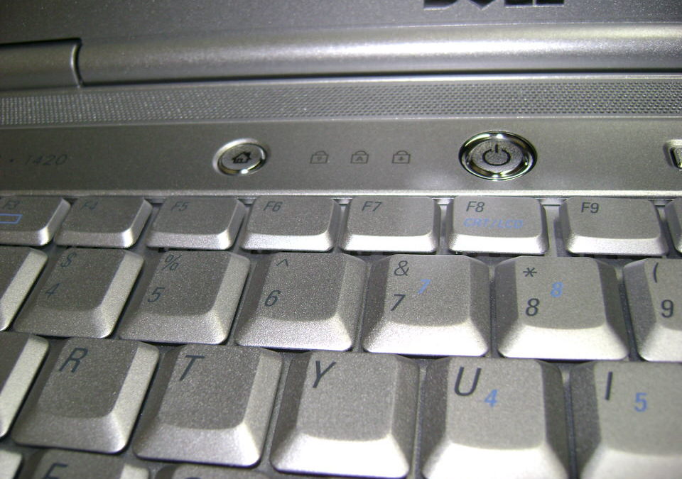A close up view of a gray dell laptop, showing a few of the keys on the top row of the keyboard, along with the power and sleep buttons.